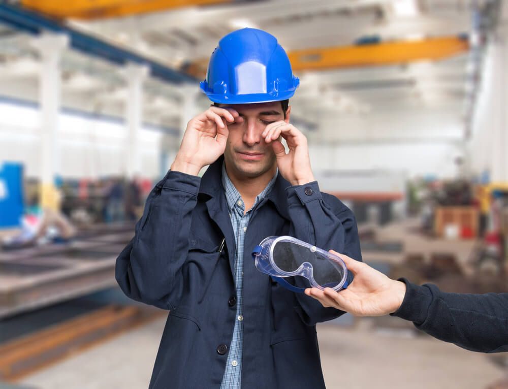 Someone offers a safety glasses to a construction worker